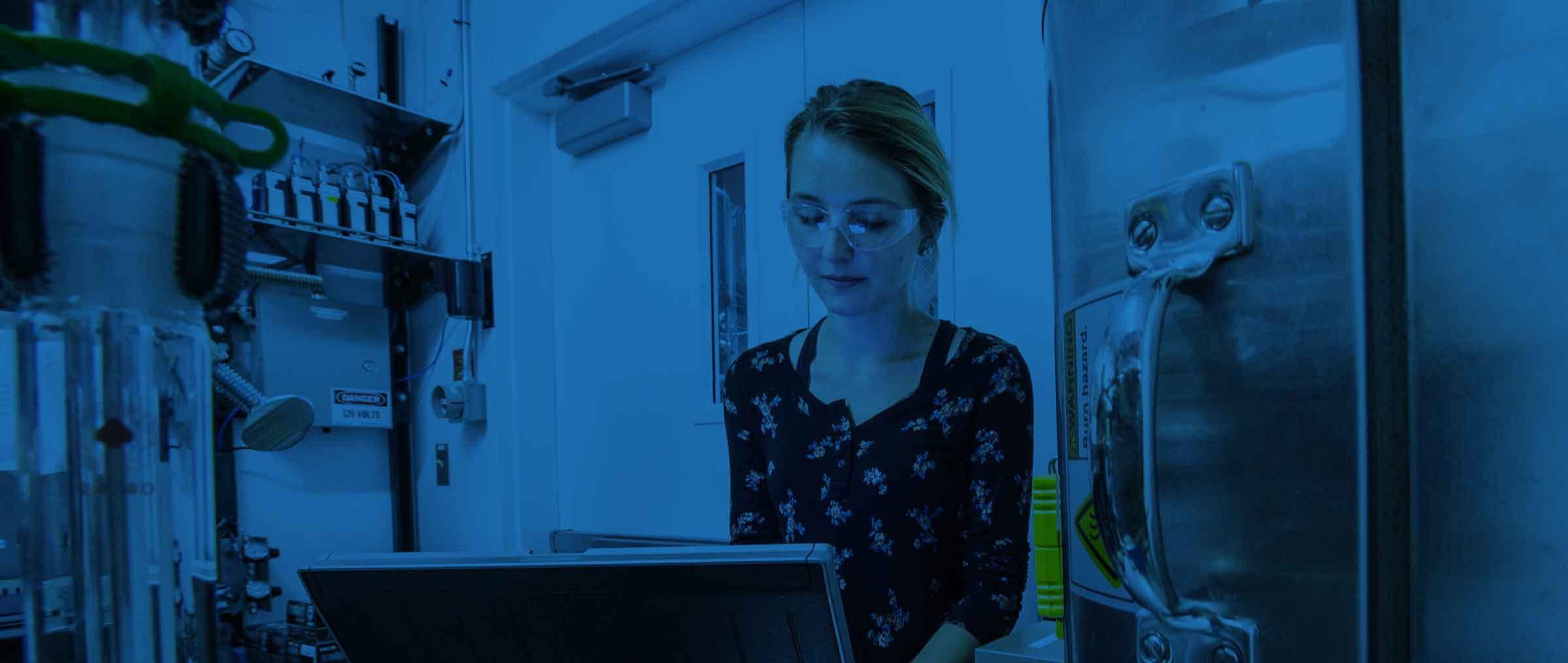 a woman in a lab looking at a computer