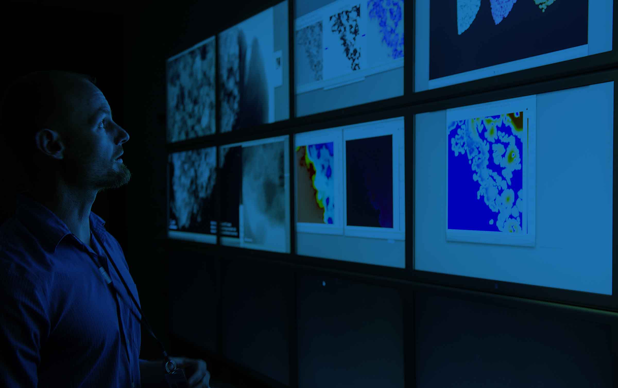 A man gazing at multiple screens with images of Biomass